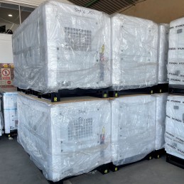 Varios grupos electrógenos industriales DG34KSE embalados y almacenados en un almacén